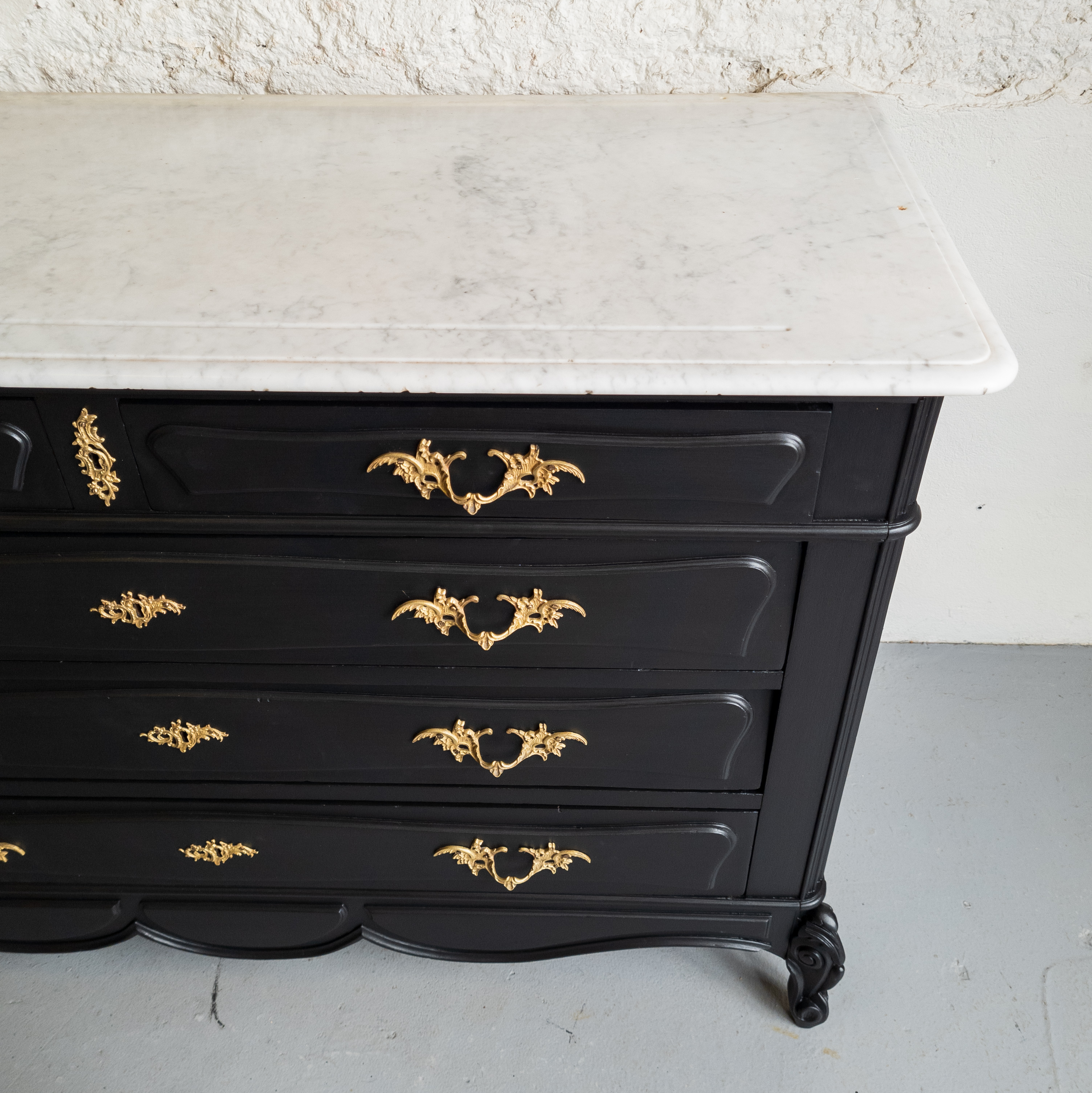 mat zwart dressoir met marmer blad en gouden handgrepen. goed gestyled brielle