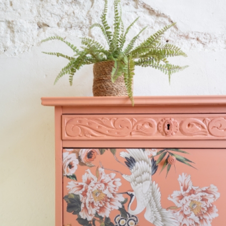 Vrolijk koraal kleurig kastje met kraanvogel en bloemen. Fusion Mineral Paint Coral. Goed gestyled brielle